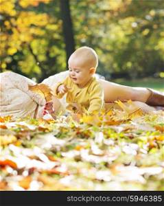 Little child playing gold autumn leaves