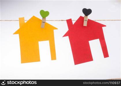 Little color paper houses attached to a string with a heart clip