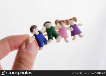 Little colorful boys and girls kid figurines in hand