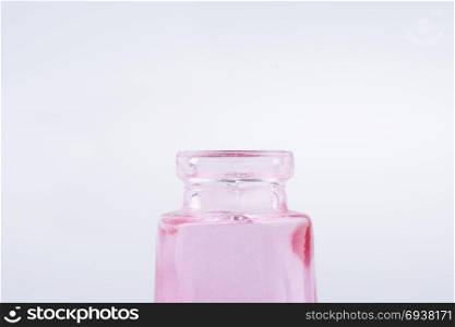 Little colorful empty glass bottle on a white background