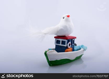 Little colorful model boat with a fake bird on white background