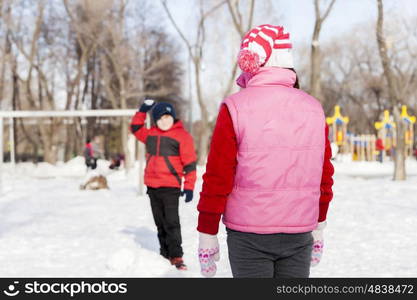 Little cute boy having fun in winter park. Winter activity