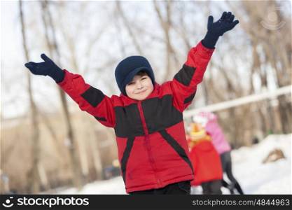 Little cute boy having fun in winter park. Winter activity
