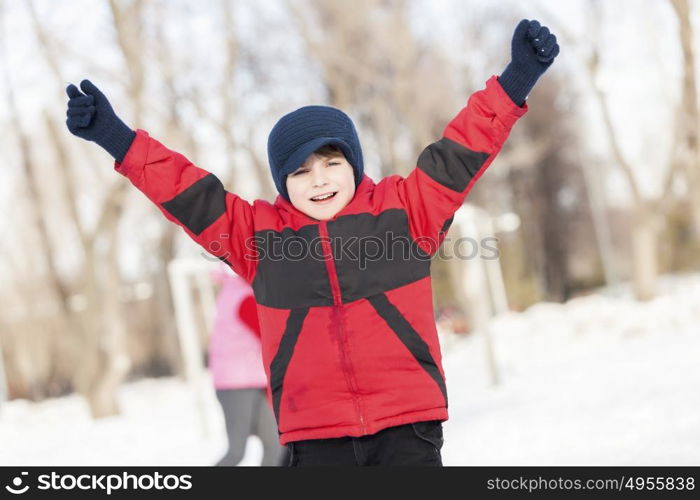 Little cute boy having fun in winter park. Winter activity