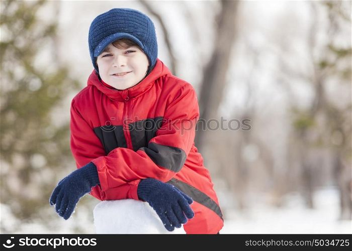 Little cute boy having fun in winter park. Winter activity