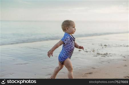 Little cute boy walking along the seaside