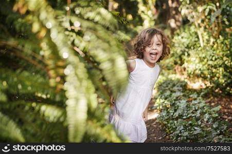 Little, cute girl having fun in a tropical garden