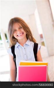 Little cute girl holding books at school