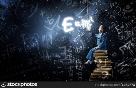 Little cute girl sitting on pile of books and pointing with finger . Kid girl study science