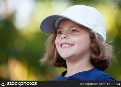 Little cute girl with a cap in the park happy