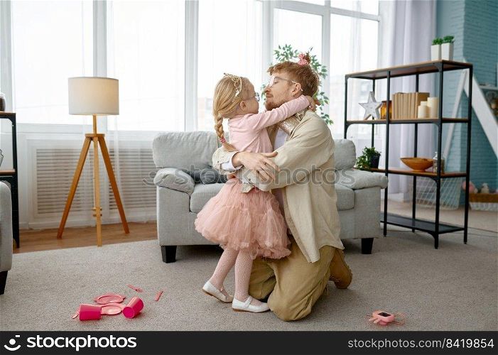 Little daughter hugging and kissing happy smiling father over home living room interior, cute family portrait. Little daughter kissing happy smiling father