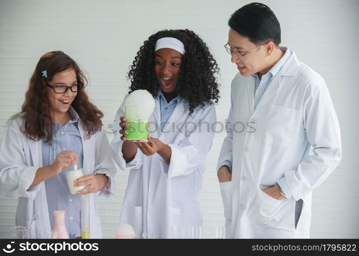 Little diversity African and Caucasian children learning chemistry in school laboratory. Asian Teacher clever little girls doing a chemical science experiment in laboratory on white background