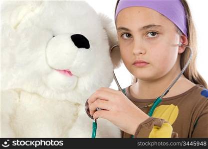 Little doctor examining her teddy a over white background