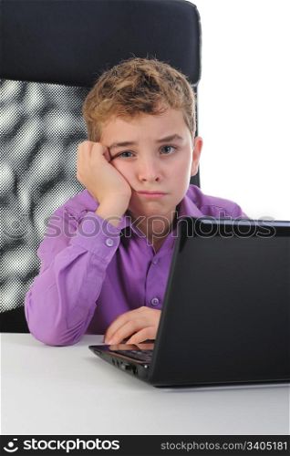 Little emotional boy sits at a computer at a desk in a bright office. Isolated on white background
