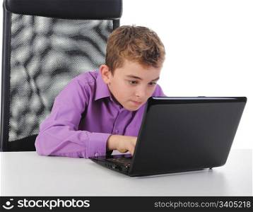 Little emotional boy sits at a computer at a desk in a bright office. Isolated on white background