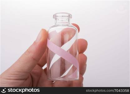 Little empty glass bottle in hand on a white background