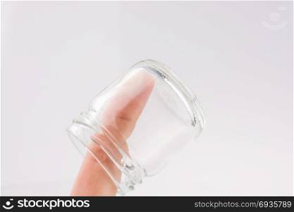 Little empty jar in hand on a white background