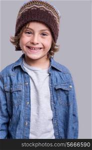 Little fashion boy posing over grey background