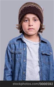 Little fashion boy posing over grey background