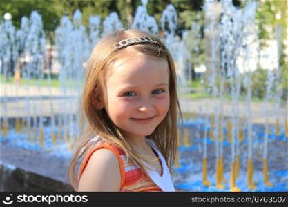 little fashionable girl on the background of fountains