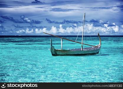 Little fishing boat in blue sea, beautiful peaceful seascape background, clear transparent water of Maldives islands