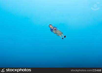 Little floating figurine in blue water