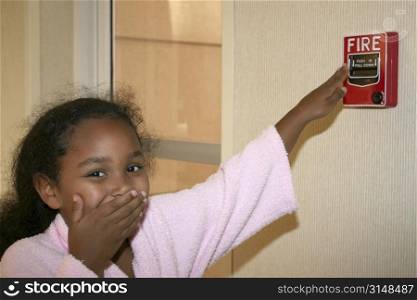 Little girl about to pull the fire alarm at a hotel.