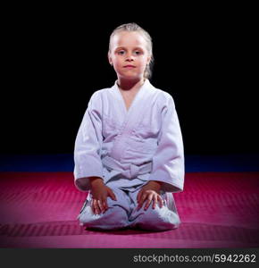 Little girl aikido fighter on black