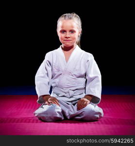 Little girl aikido fighter on black