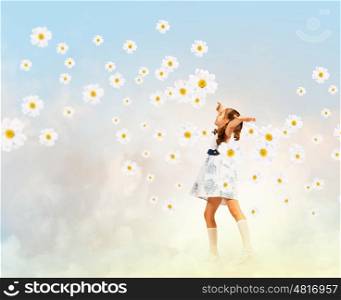 Little girl among flowers. Image of little pretty girl playing among chamomiles