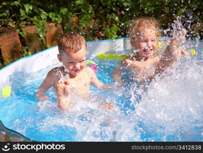 Little girl and boy play in small pool - bath