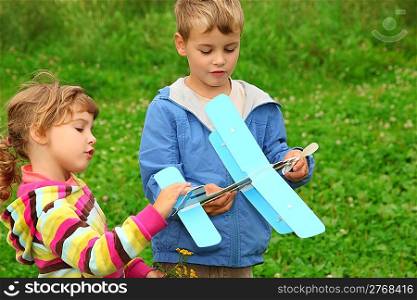 little girl and boy with toy airplane in hands outdoor