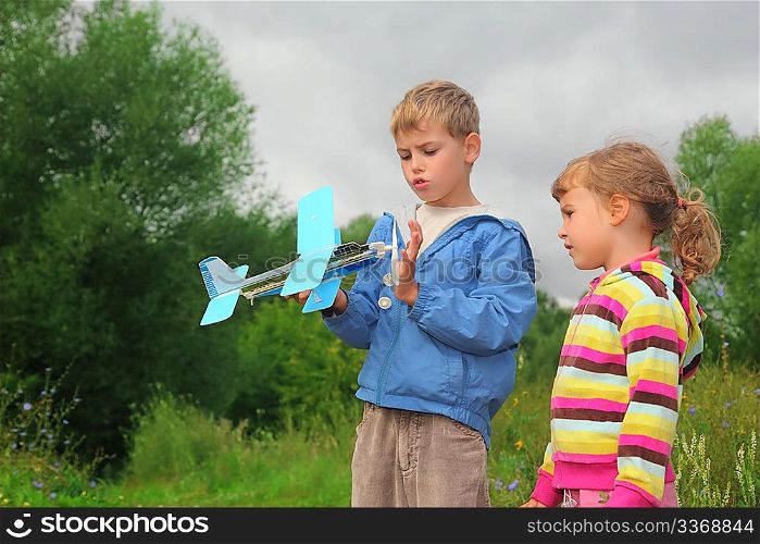 little girl and boy with toy airplane in hands outdoor