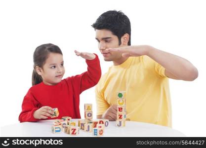 Little girl and father playing block game