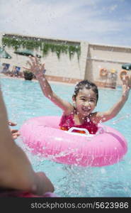 Little girl and her father splashing in the pool