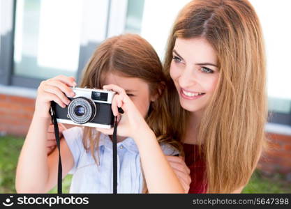 Little girl and her mother or sister shooting with a vintage camera