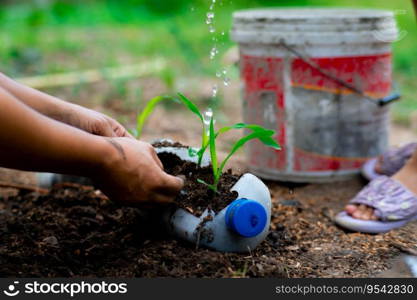 Little girl and mom grow plants in pots from recycled water bottles in the backyard. Recycle water bottle pot, gardening activities for children. Recycling of plastic waste