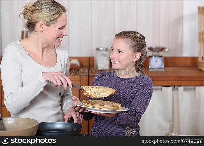 Little girl and mother about to eat pancakes for breakfast