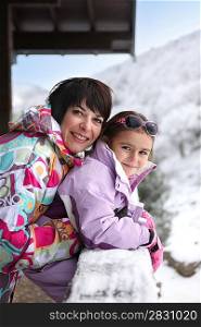 Little girl and mother at their ski cottage