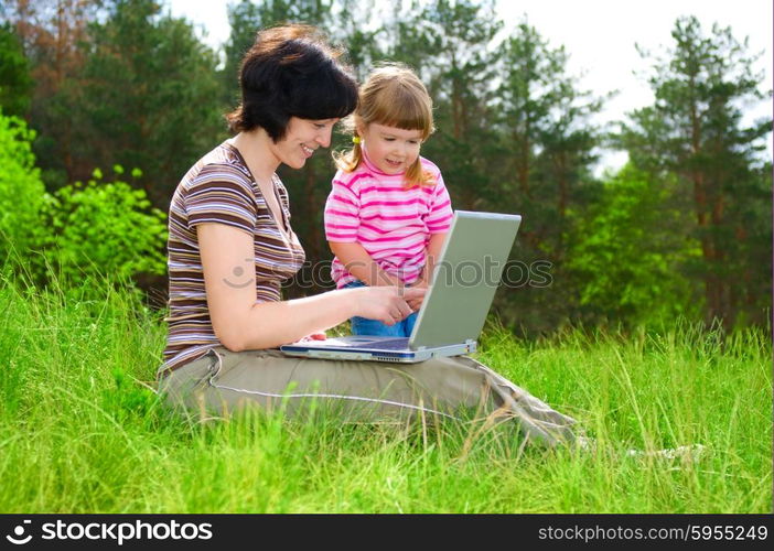 Little girl and mother with laptop outdoor