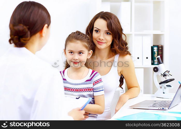 Little girl and young doctor in hospital having examination