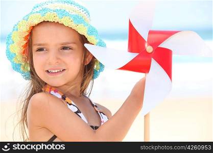 little girl at beach with toy windmill