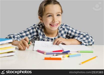 Little girl at school making drawings and painting