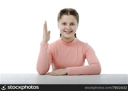 Little girl at the table in school isolated on white