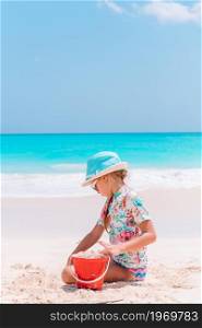 Little girl at tropical beach making sand castle on summer vacation. Little girl at tropical white beach making sand castle