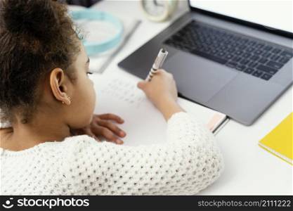 little girl attending online school home using laptop