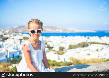 Little girl background beautiful old greek Mykonos. Adorable little girl at old street of typical greek traditional village