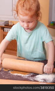 Little girl baking rolling pastry for Christmas cookies