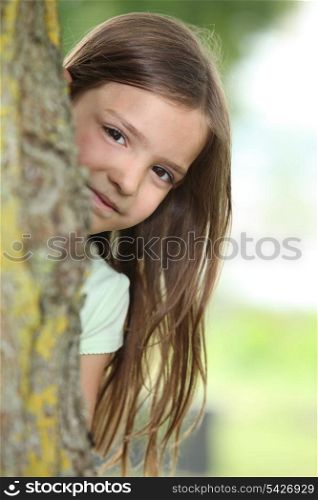 Little girl behind a tree