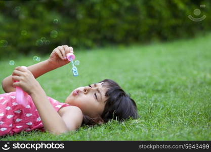 Little girl blowing bubbles